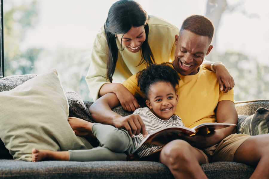 young family reading on couch